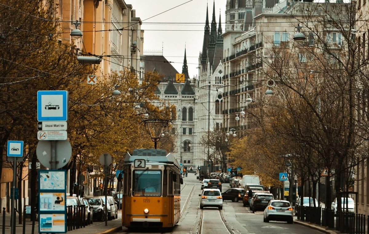 Budapesti utca villamossal, autókkal és a Parlament kupolájával