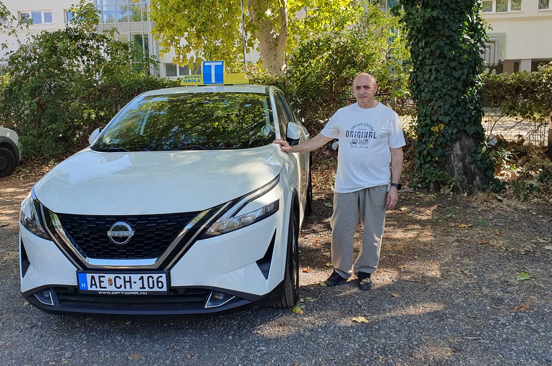 Anda János az oktatóautó mellett